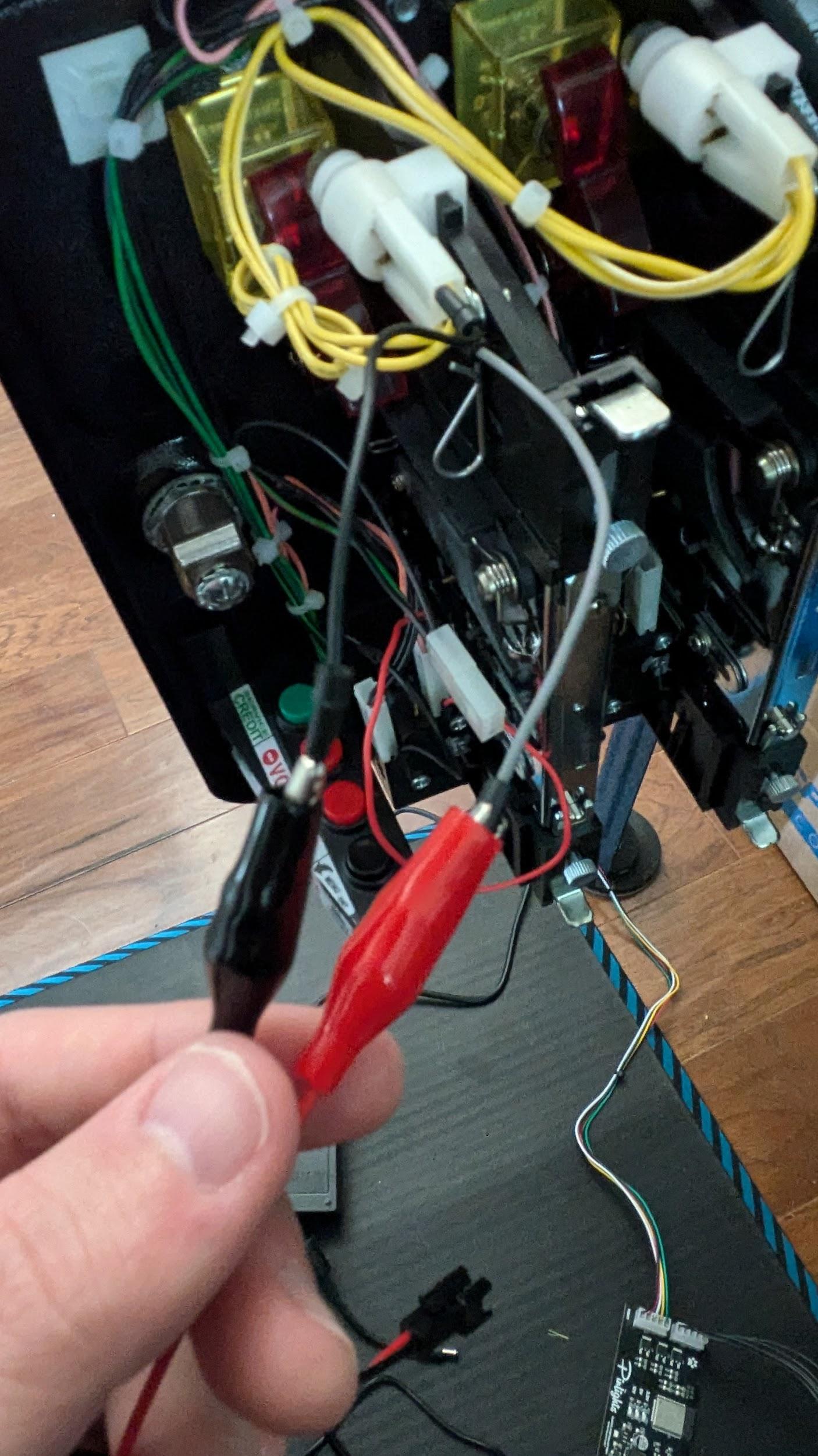 Alligator clips attached to wire taps on a JJP coin door bulb